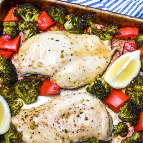 sheet pan lemon chicken and roasted vegetables on a metal baking pan