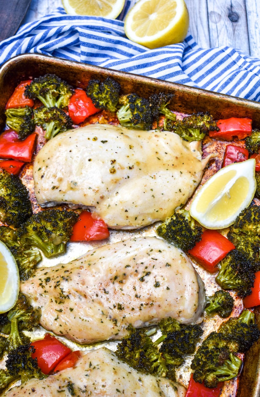 sheet pan lemon chicken and roasted vegetables on a metal baking pan