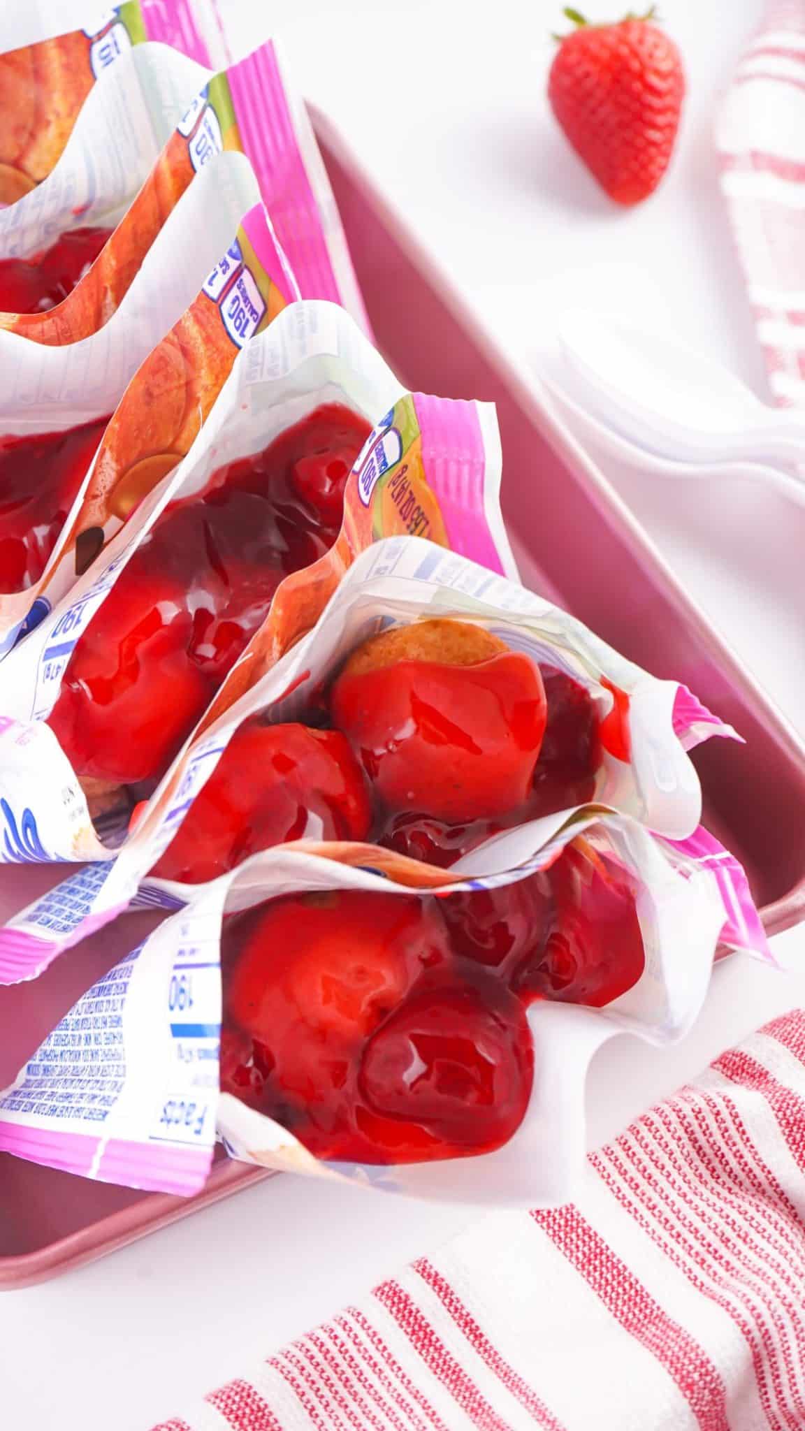 strawberry pie filling spooned over little bite muffins in their packaging