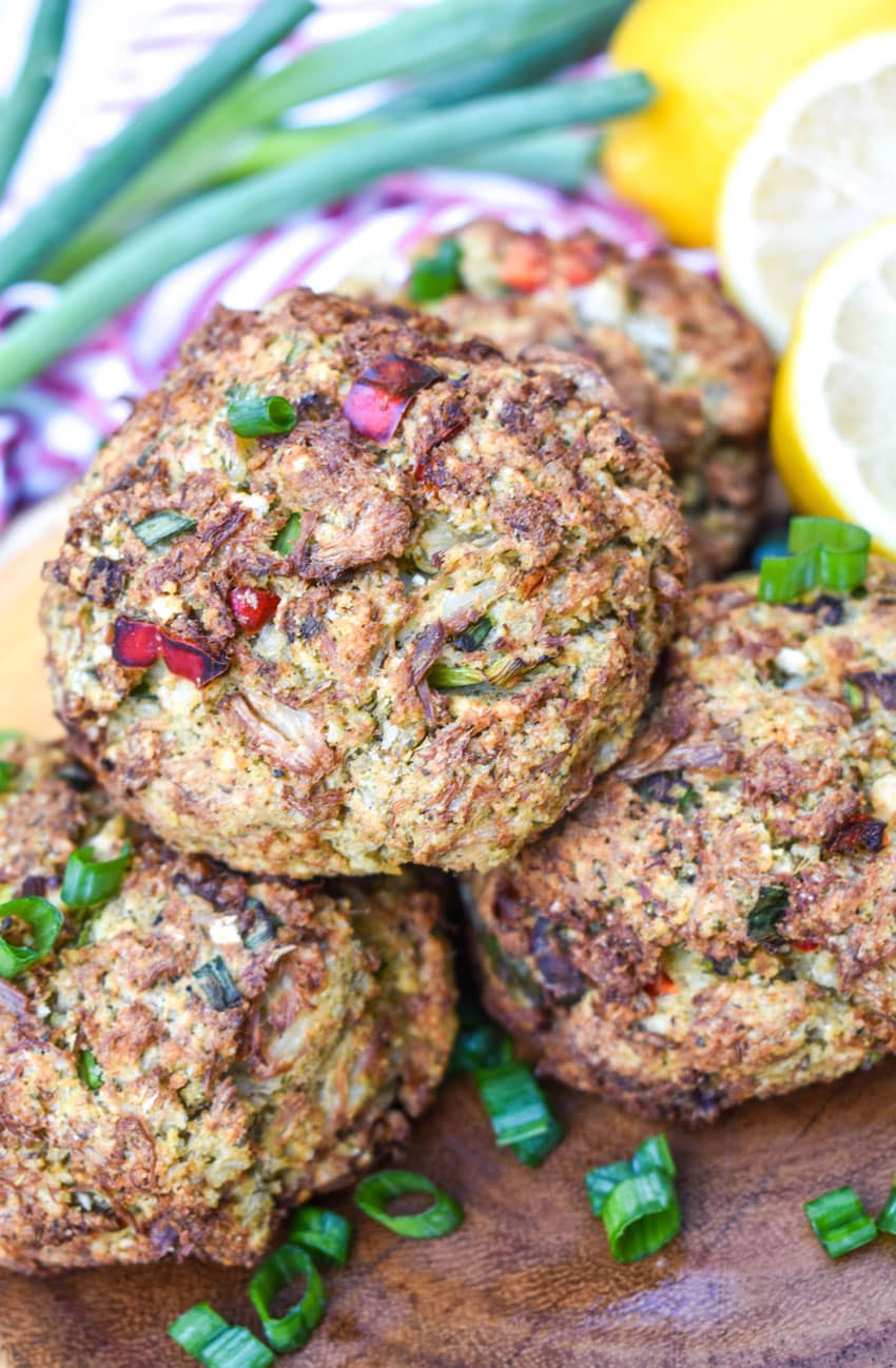 a stack of air fryer crab cakes on a wooden cutting board