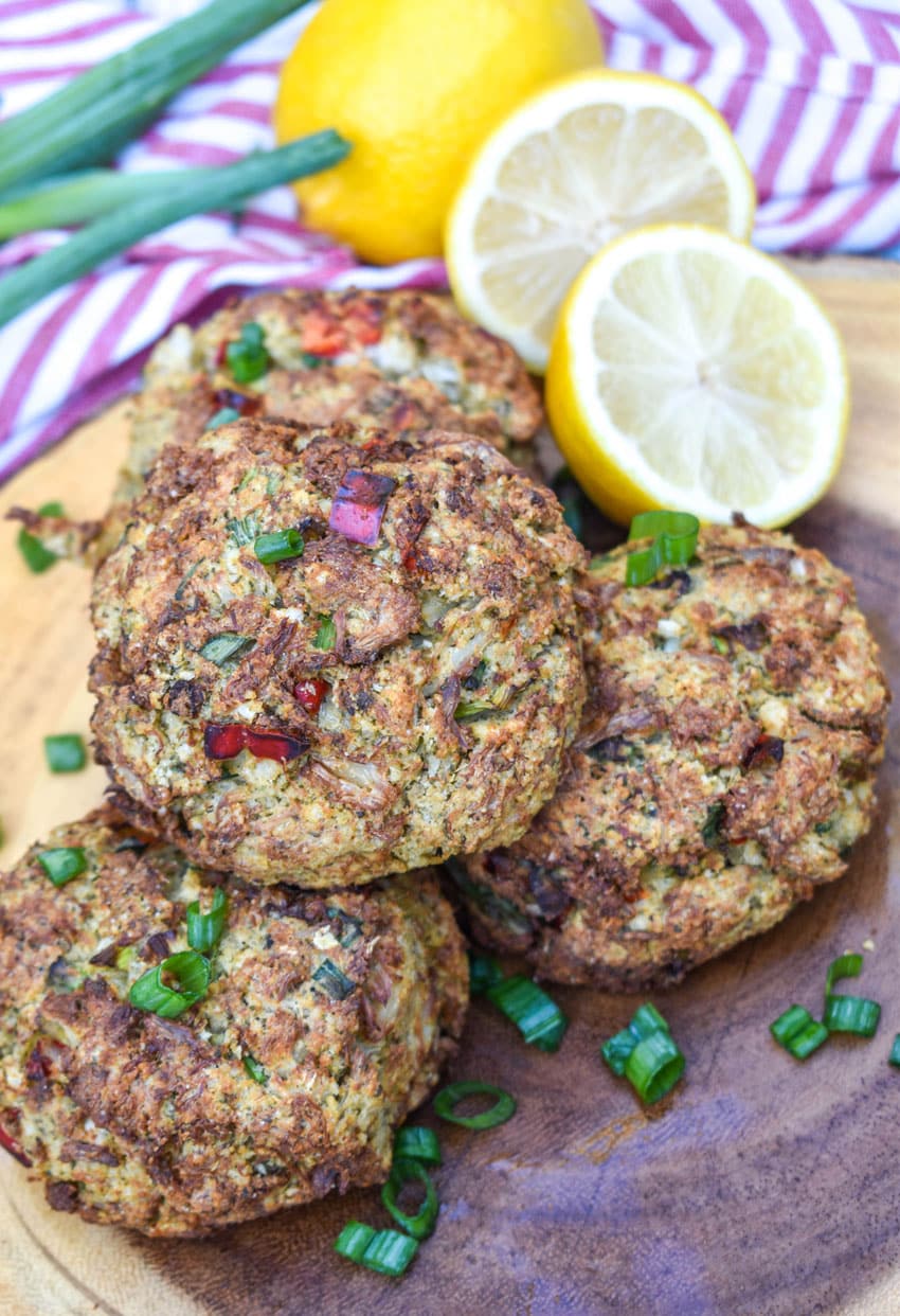 a stack of air fryer crab cakes on a wooden cutting board