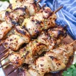 air fryer lemon chicken skewers topped with grated lemon zest piled on a wooden cutting board