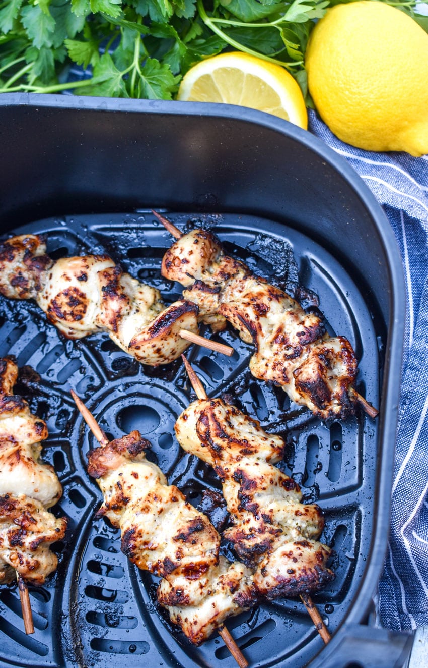 lemon chicken skewers in the basket of an air fryer