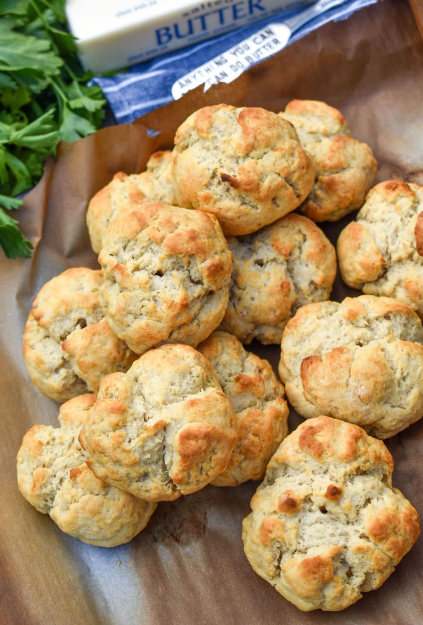 a pile of easy drop biscuits on a parchment lined baking sheet
