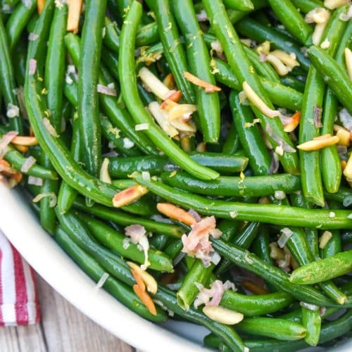 easy green bean almondine in a white serving dish
