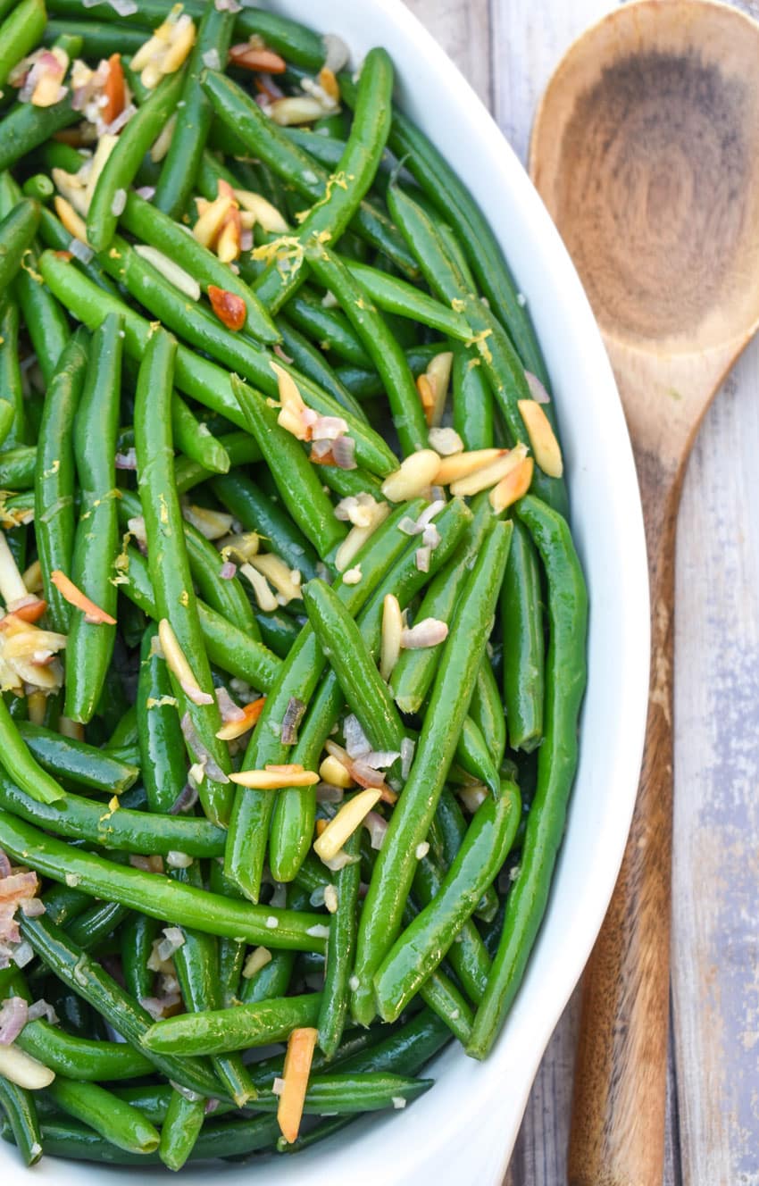 easy green bean almondine in a white serving dish