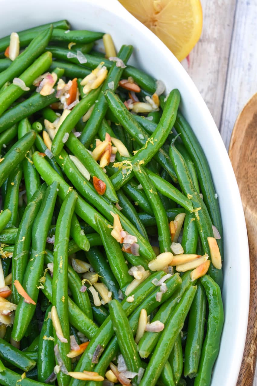 easy green bean almondine in a white serving dish
