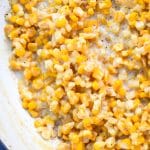 a close up of creamy honey butter skillet corn in a cast iron skillet