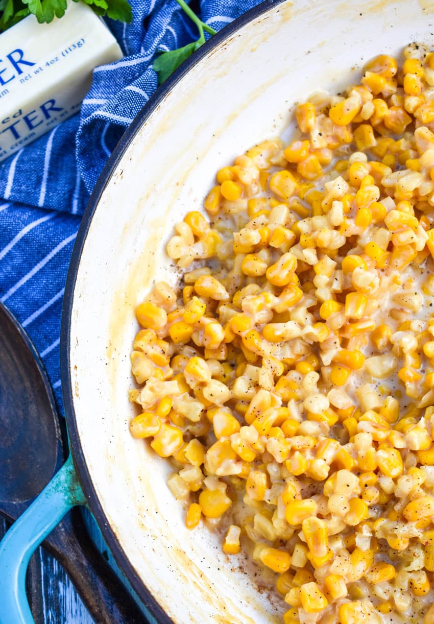 a close up of creamy honey butter skillet corn in a cast iron skillet