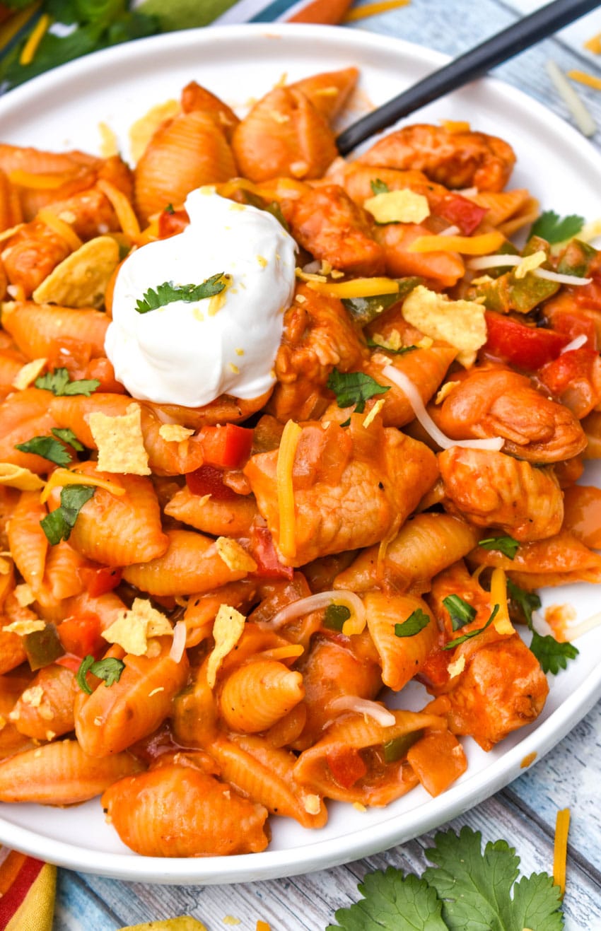 one pot chicken fajita pasta on a white dinner plate with a lime wedge on the side