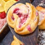 a wooden spatula holding up a raspberry lemon danish