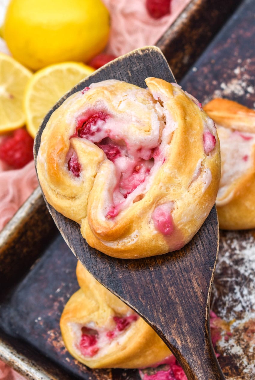 a wooden spatula holding up a raspberry lemon danish