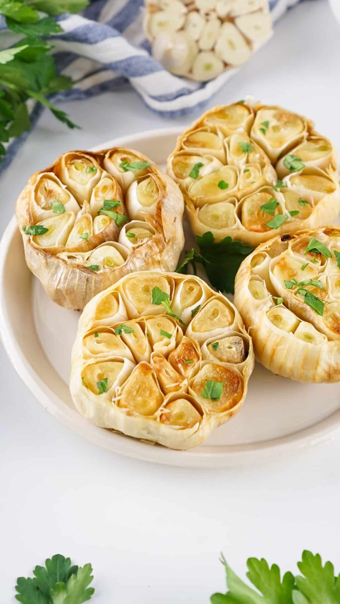 roasted garlic bulbs resting on a white plate