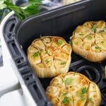roasted garlic cloves in the basket of an air fryer