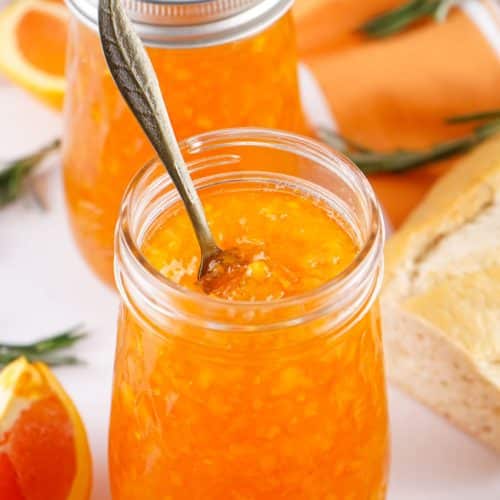 homemade orange marmalade in two glass canning jars