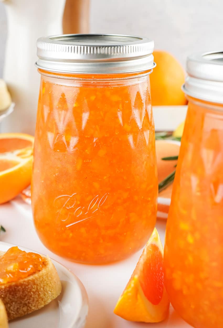 homemade orange marmalade in two glass canning jars
