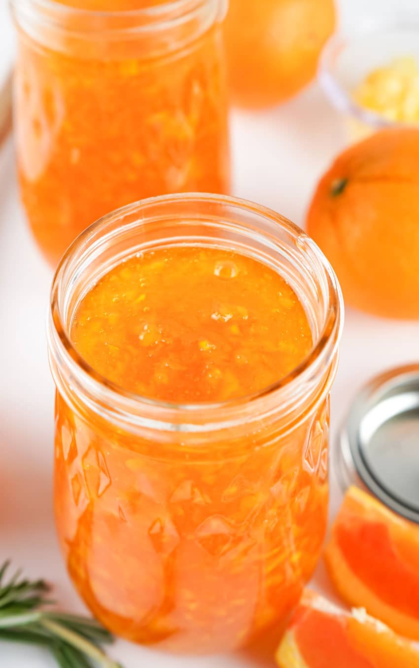 homemade orange marmalade in two glass canning jars