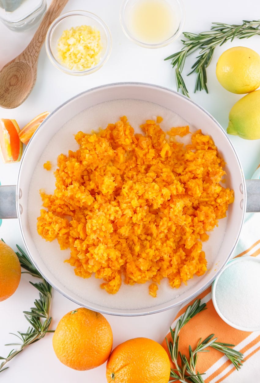 orange pulp in a large pot with sugar