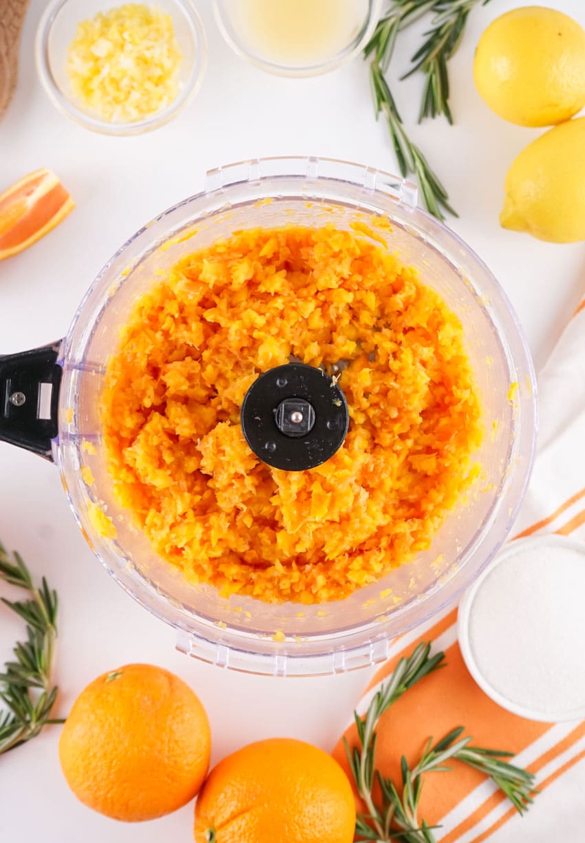 pulsed orange pulp in the bowl of a food processor