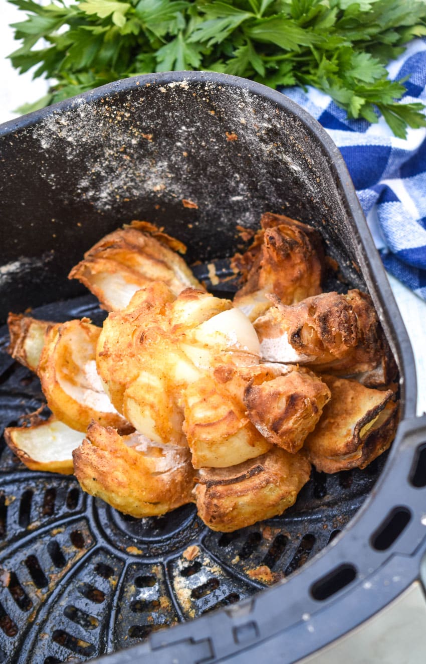 an air fried bloomin' onion in the basket of an air fryer
