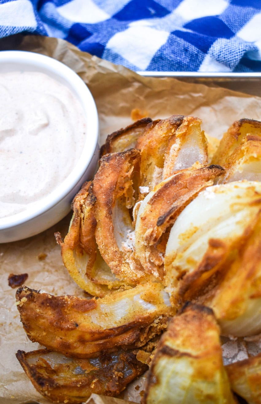 air fryer bloomin' onion on a brown parchment paper lined tray