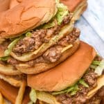 two big mac sloppy joes stacked on top of each other with crispy fries on the side