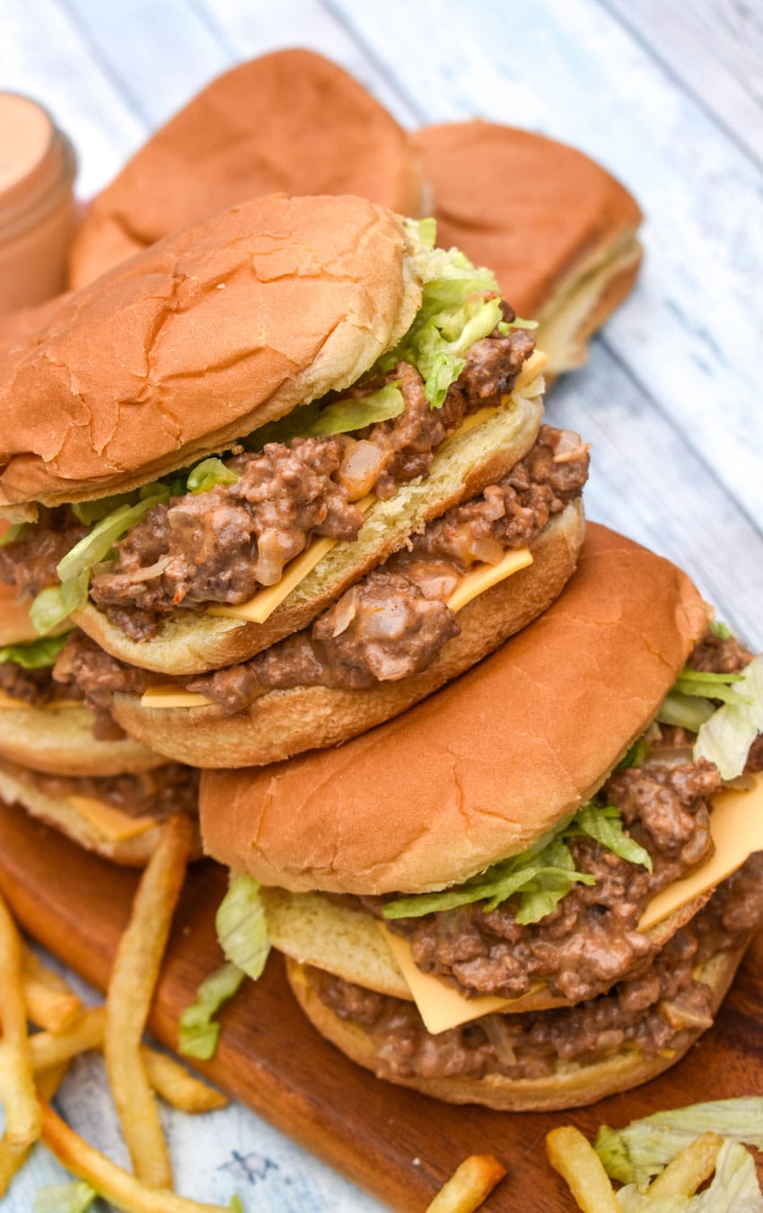two big mac sloppy joes stacked on top of each other with crispy fries on the side