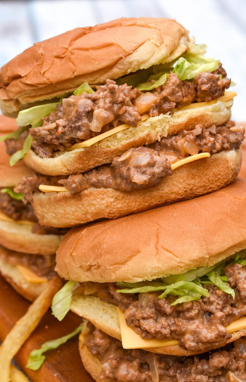 two big mac sloppy joes stacked on top of each other with crispy fries on the side
