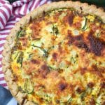 a cheesy zucchini quiche on a wooden table