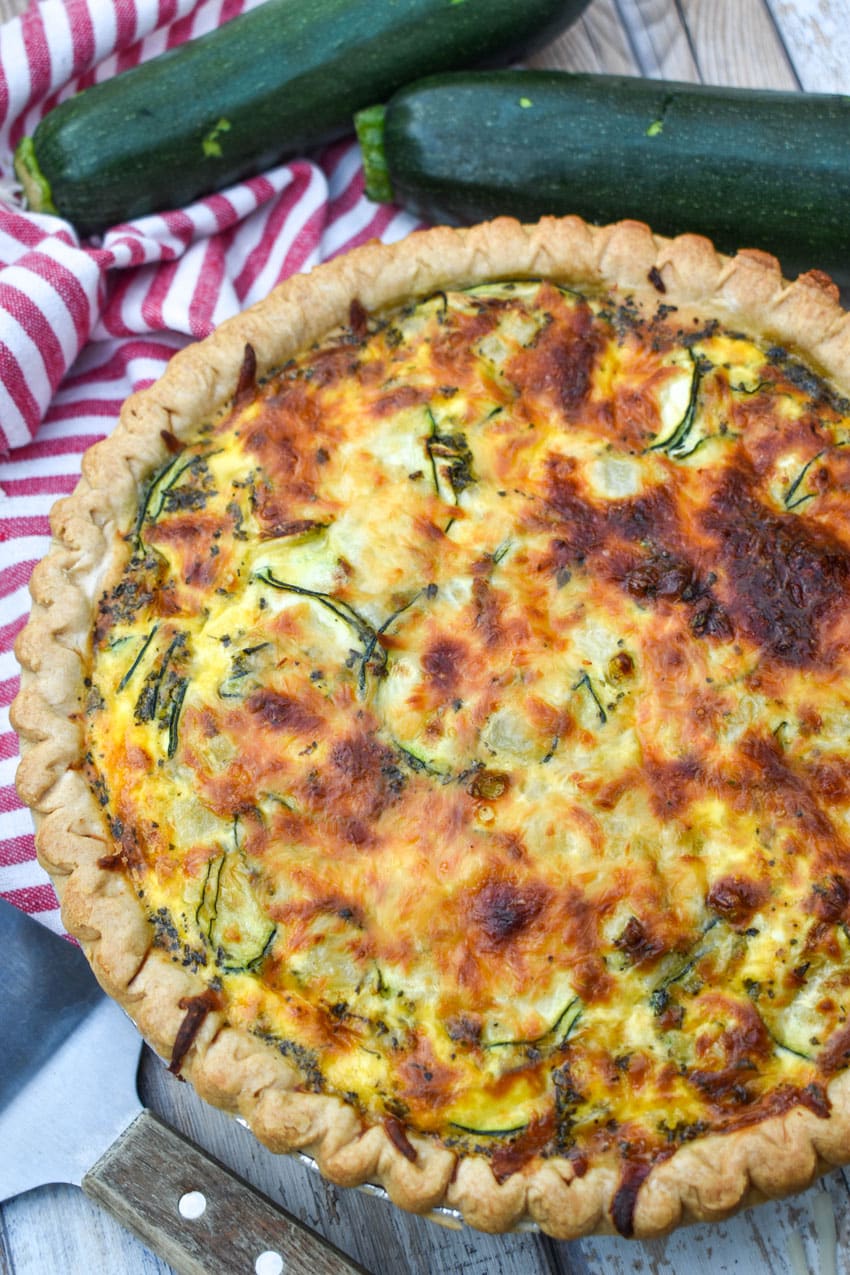 a cheesy zucchini quiche on a wooden table