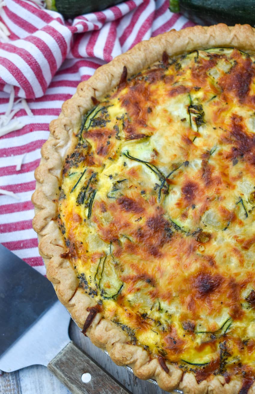 a cheesy zucchini quiche on a wooden table