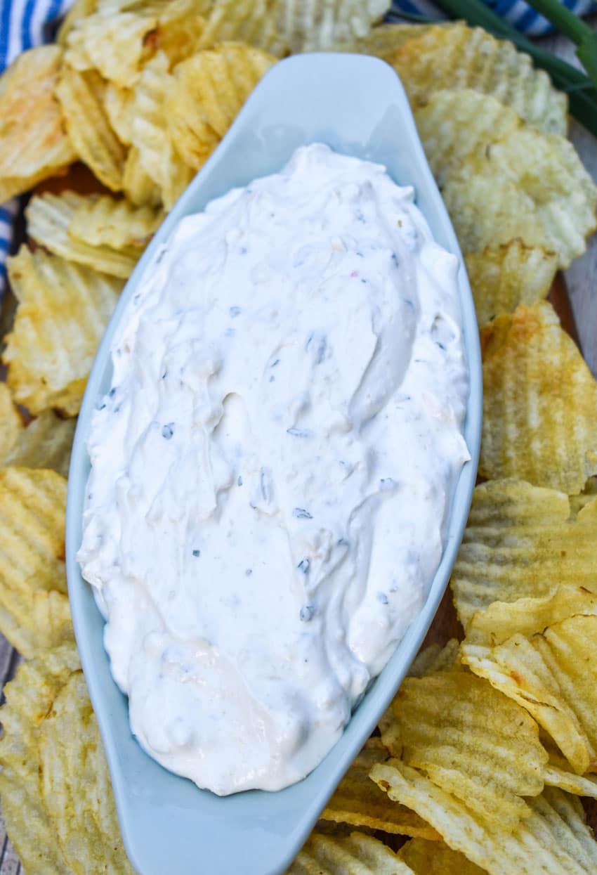 copycat dean's french onion dip in a small gray serving bowl surrounded by potato chips