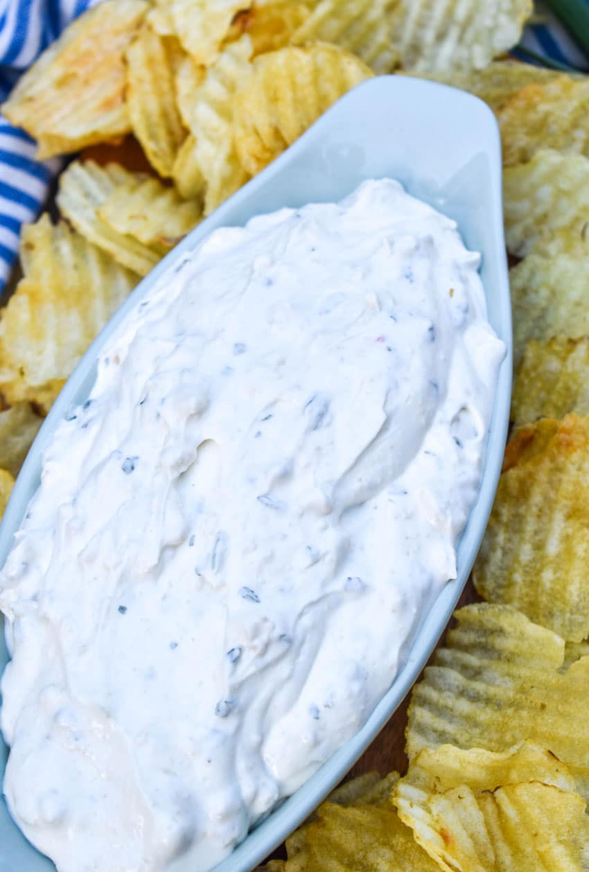 copycat dean's french onion dip in a small gray serving bowl surrounded by potato chips