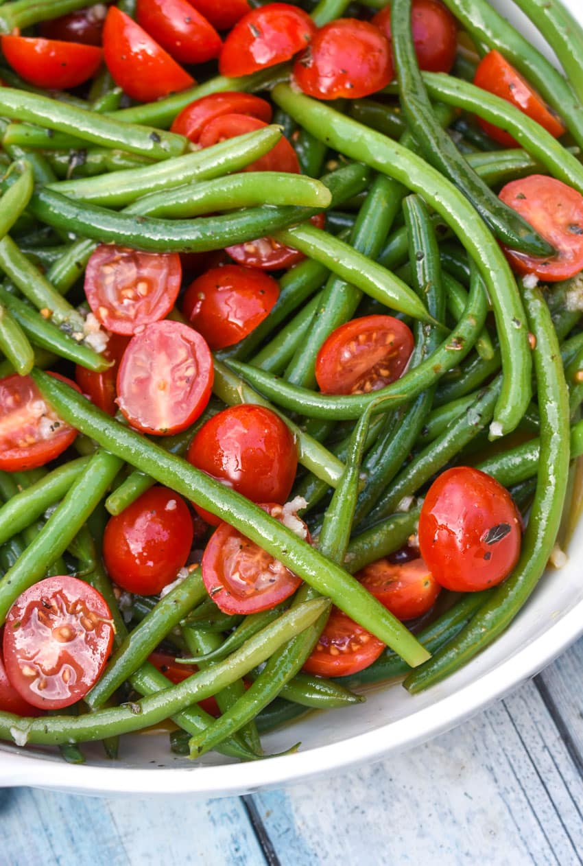 green bean and tomato salad in a large white serving bowl