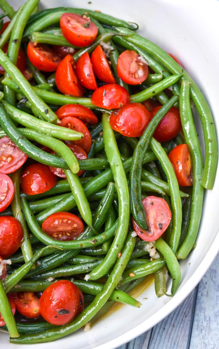 green bean and tomato salad in a large white serving bowl