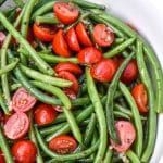 green bean and tomato salad in a large white serving bowl