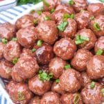 the best party meatballs piled high in a white serving bowl
