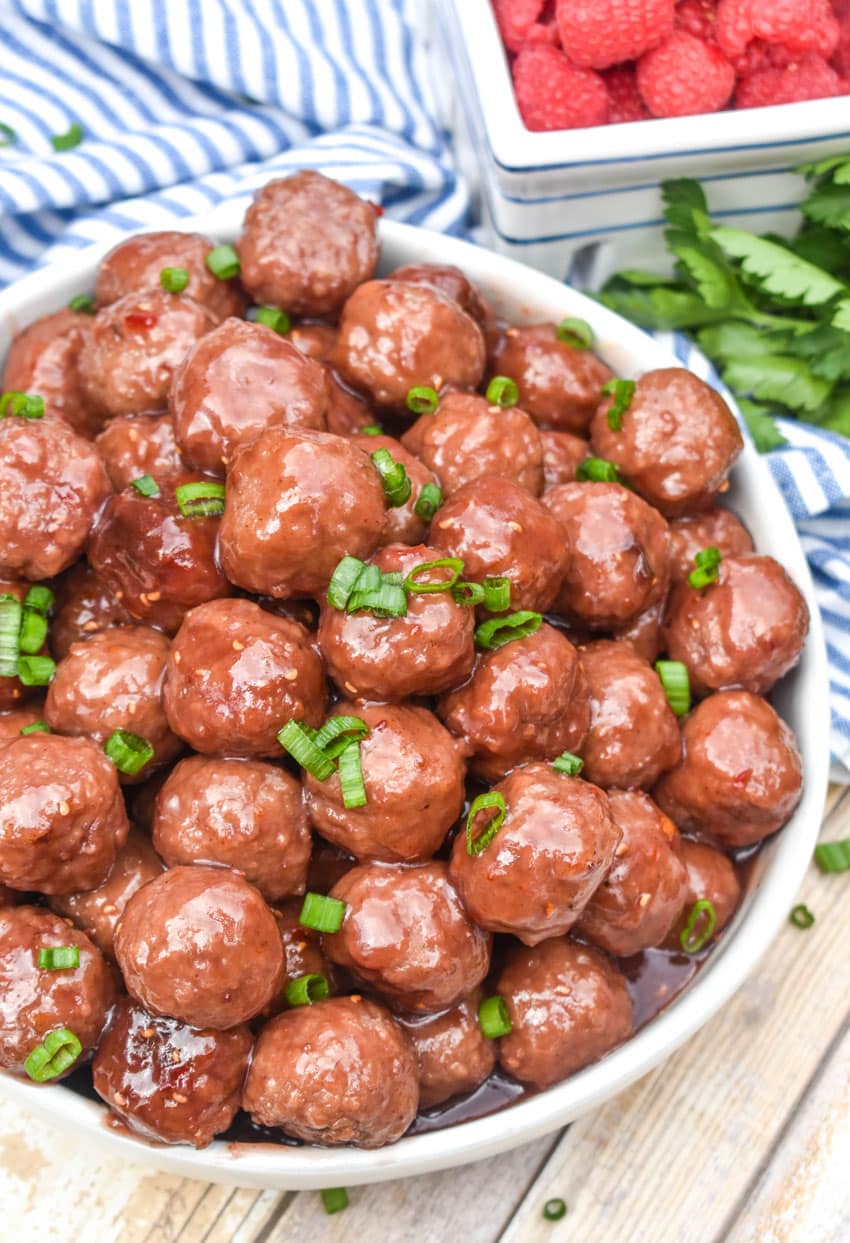 the best party meatballs piled high in a white serving bowl