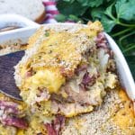 a wooden spatula holding up a slice of reuben casserole