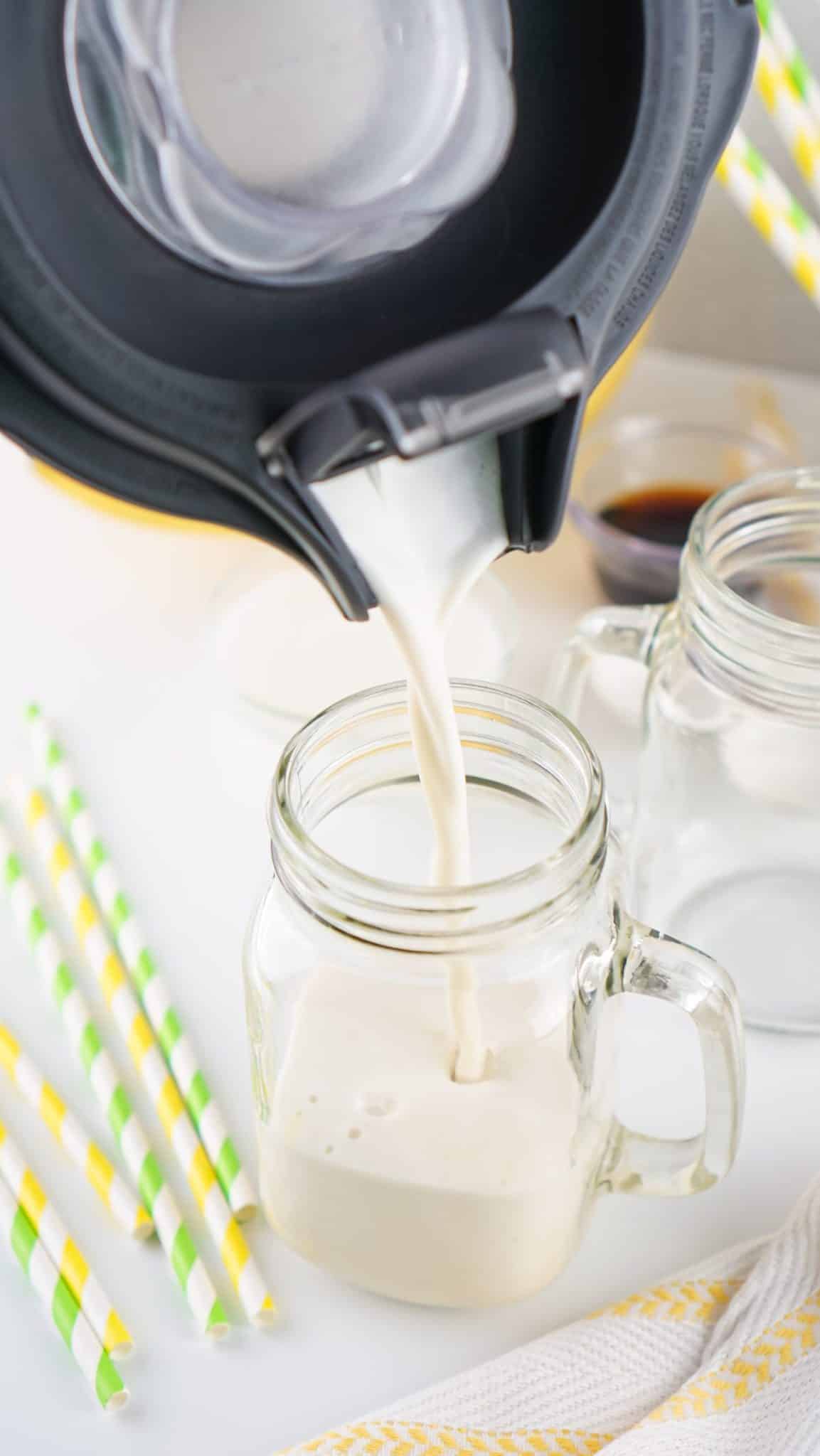 homemade banana milk being poured into a glass drinking jar