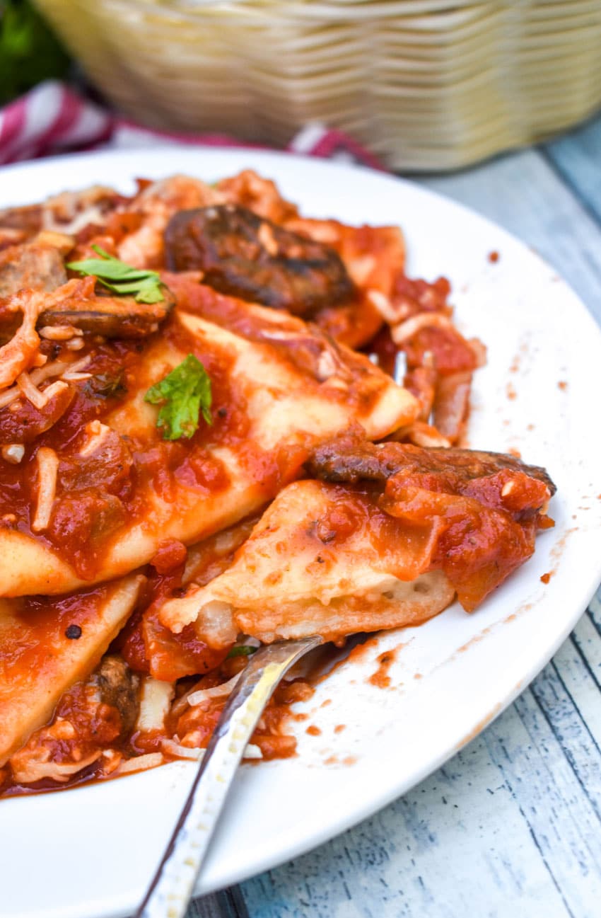 dump and bake italian pierogi bake on white plate with fresh herbs sprinkled on top
