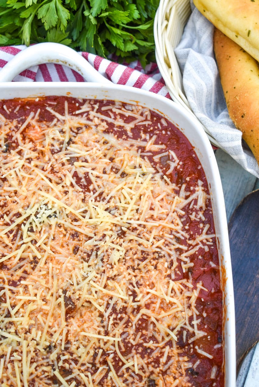 italian pierogi bake in a white casserole dish topped with melted shredded parmesan cheese