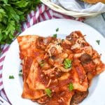 dump and bake italian pierogi bake on white plate with fresh herbs sprinkled on top