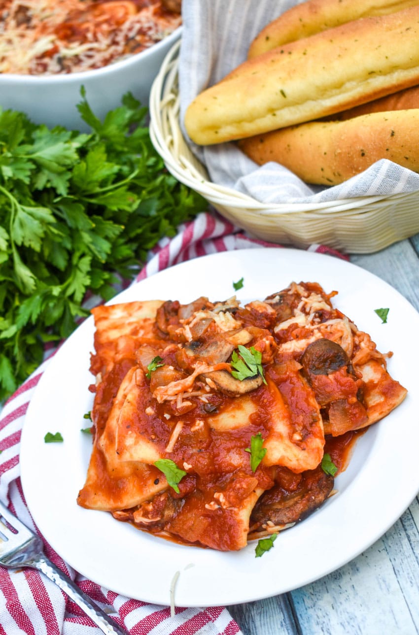 dump and bake italian pierogi bake on white plate with fresh herbs sprinkled on top