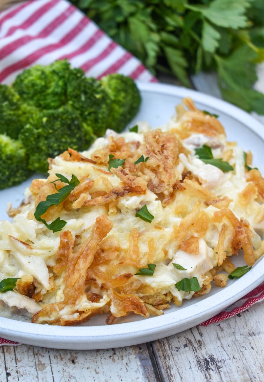 french onion chicken casserole served on a white plate with steamed broccoli on the side