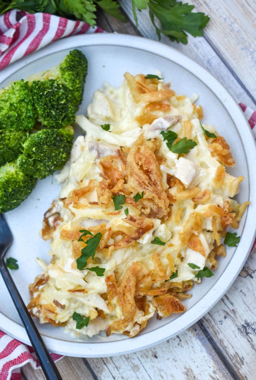 french onion chicken casserole served on a white plate with steamed broccoli on the side