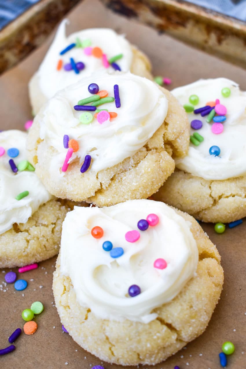 frosted cake mix sugar cookies on a parchment lined baking sheet