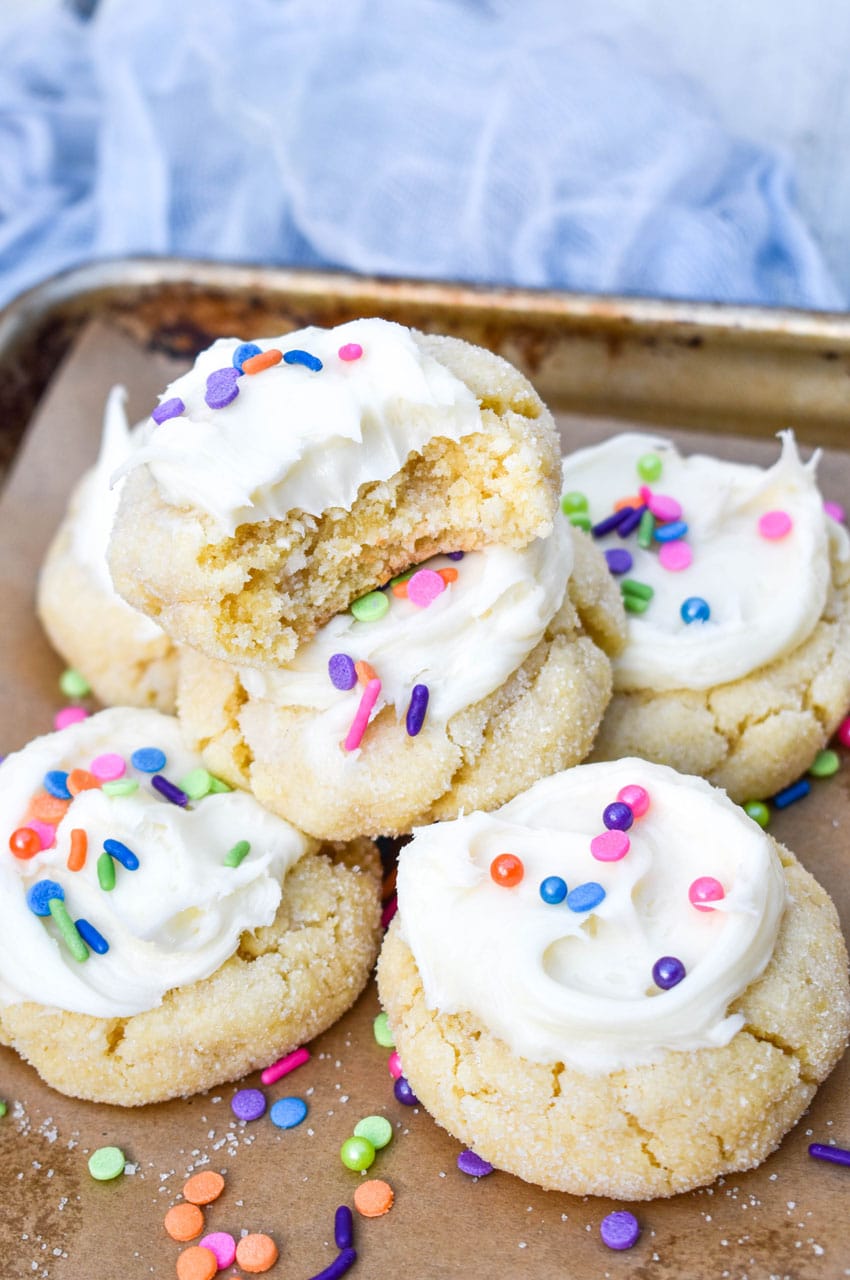 frosted cake mix sugar cookies on a parchment lined baking sheet