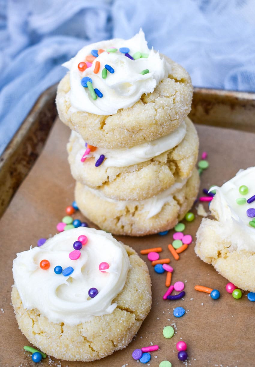 frosted cake mix sugar cookies on a parchment lined baking sheet