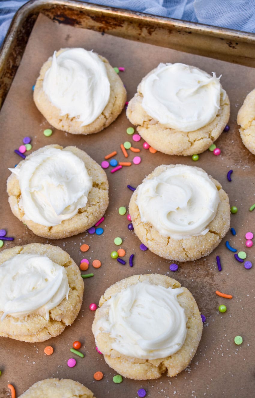 frosted cake mix sugar cookies on a parchment lined baking sheet